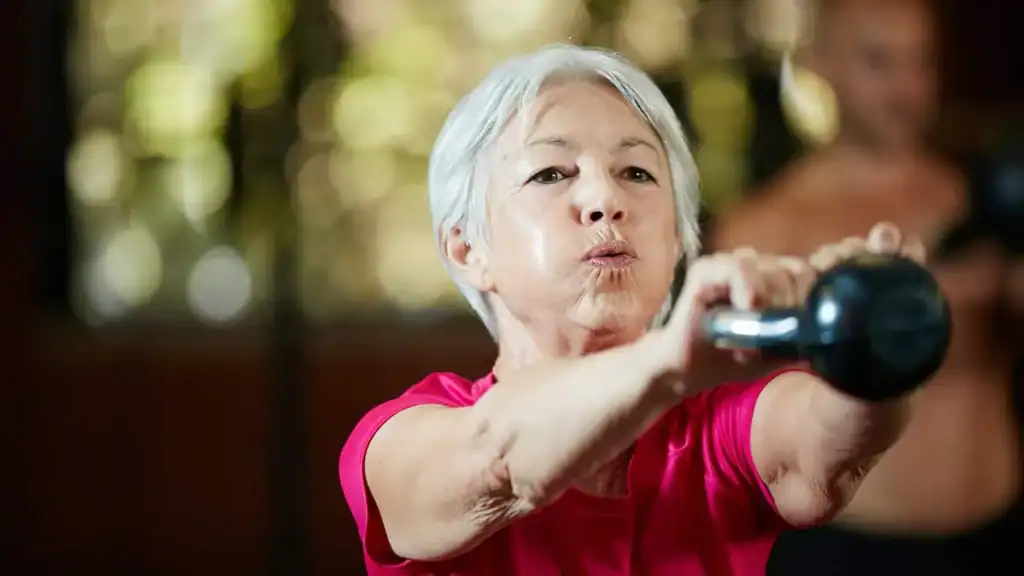 Older woman doing weight training Market Harborough to help her strength and longevity 