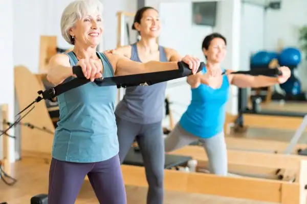 Toning Arms After 60: Empowering Womens Fitness Through Effective Weight Training 2 older woman doing weight training Market Harborough and resistance in the gym to tone upper arms