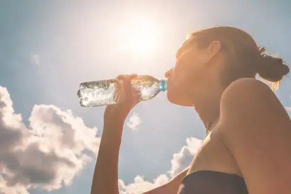 Hydration: The Secret Ingredient for a Toned Stomach and Enhanced Fitness 3 Image of woman drinking water to hydrate Market Harborough after run.